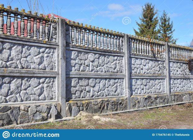 concrete-fence-panel-design-stone-foundation-against-blue-sky-179476145